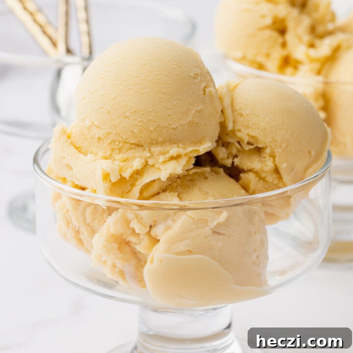 a footed glass dish with smooth sides, filled with four scoops of oat milk ice cream.