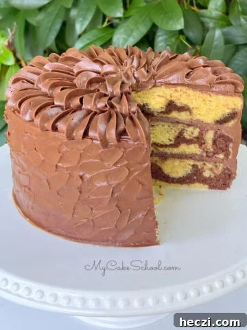 Sliced Marble Cake from cake mix, frosted with chocolate buttercream, resting on a white cake pedestal.