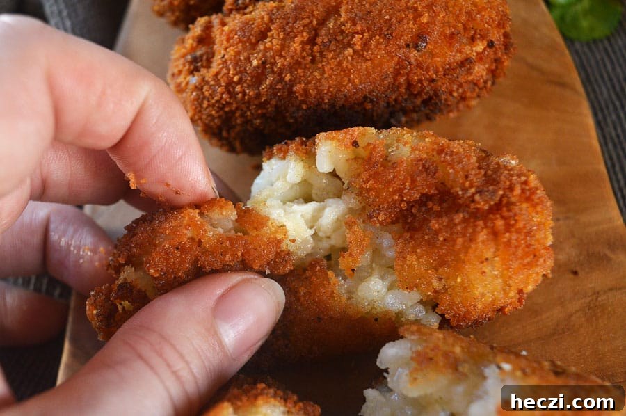 Vegan Supplì: How to Make Italy’s Crispy Fried Rice Balls 3 Orange rice croquettes being pinched apart