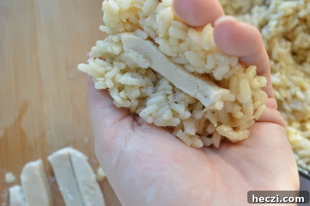 Vegan Supplì: How to Make Italy’s Crispy Fried Rice Balls 5 A hand with white risotto and vegan mozzarella in the middle