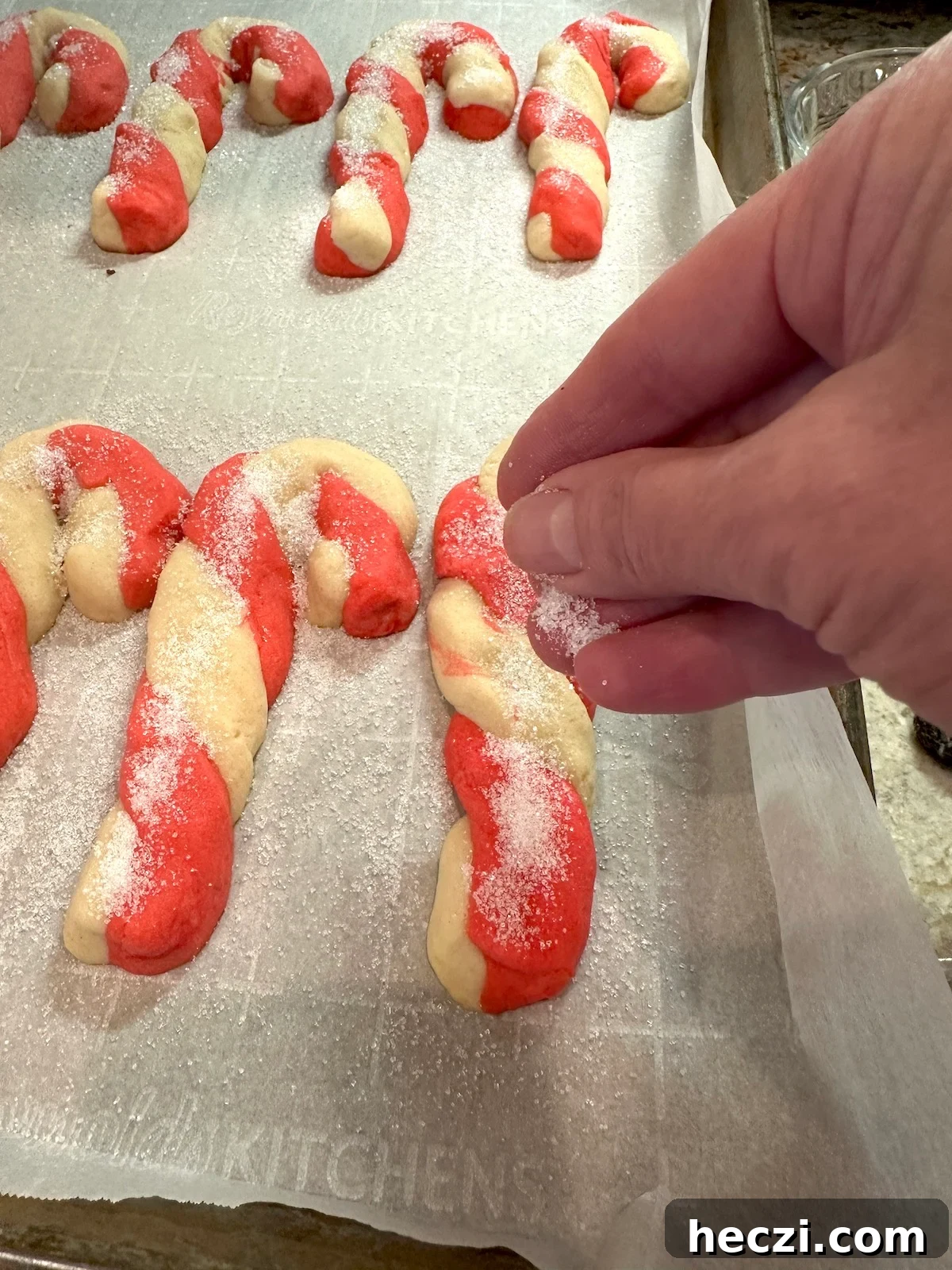 Peppermint Candy Cane Cookies Recipe for Festive Holidays 15 Sugar sprinkled on Christmas candy cane cookies on a baking sheet.