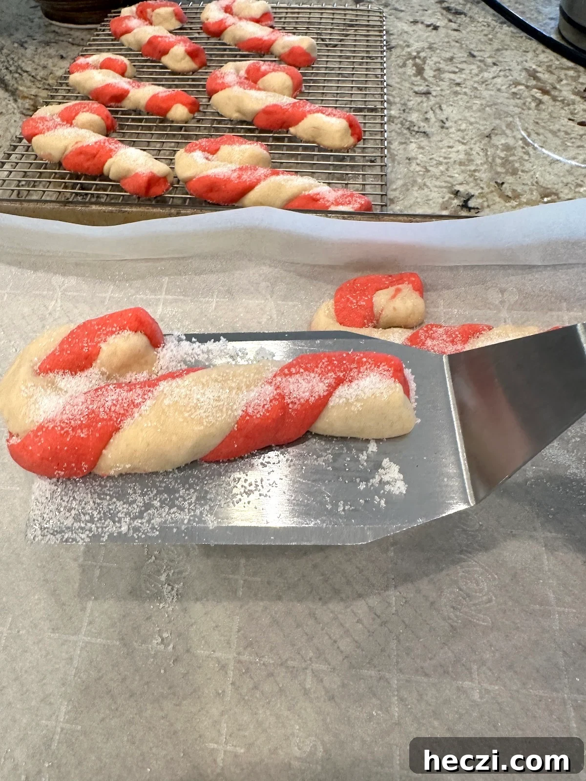 Peppermint Candy Cane Cookies Recipe for Festive Holidays 16 A spatula lifts a Christmas cookie from a baking sheet.