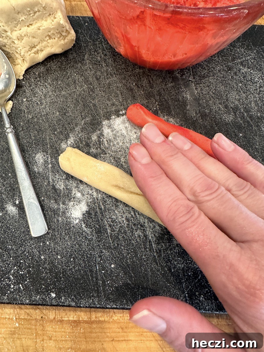 Peppermint Candy Cane Cookies Recipe for Festive Holidays 10 Rolling candy cane cookie dough on a cutting board.