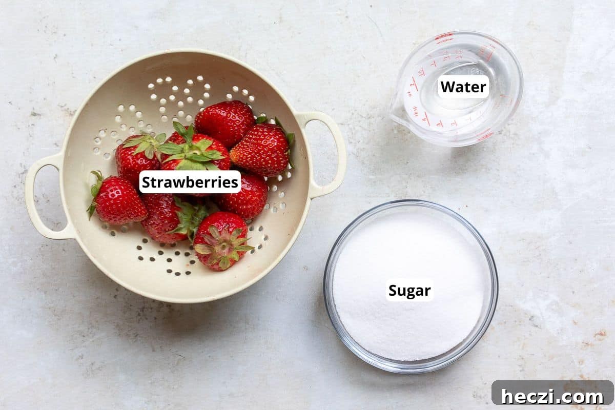 Homemade Strawberry Syrup Recipe for Drinks & Desserts 3 A colander with strawberries, a glass bowl of sugar, and a measuring cup of water arranged on a light surface.
