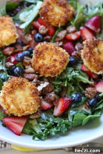 Strawberry salad with fried goat cheese in serving dish.