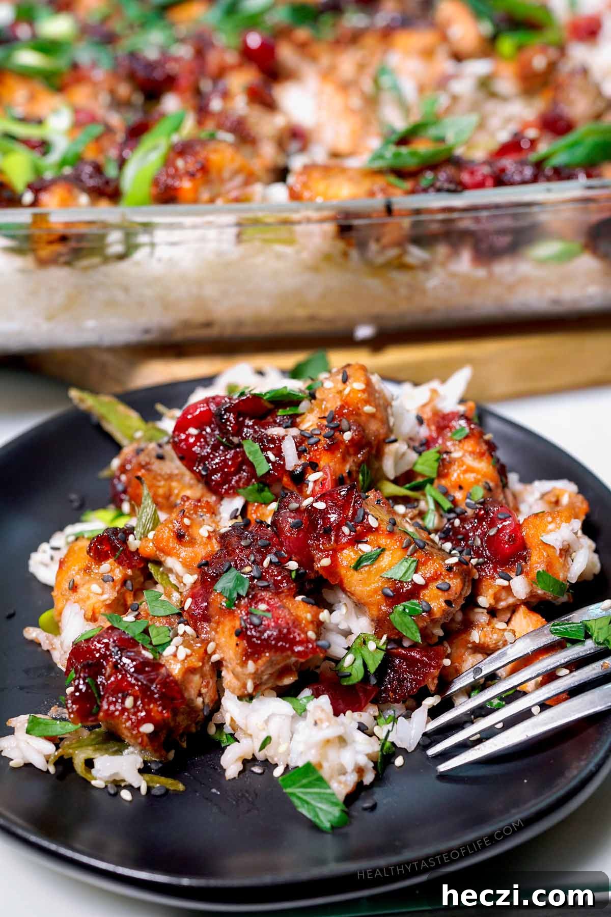 Salmon casserole with cranberry serving on a plate with a sprinkle of sesame seeds.