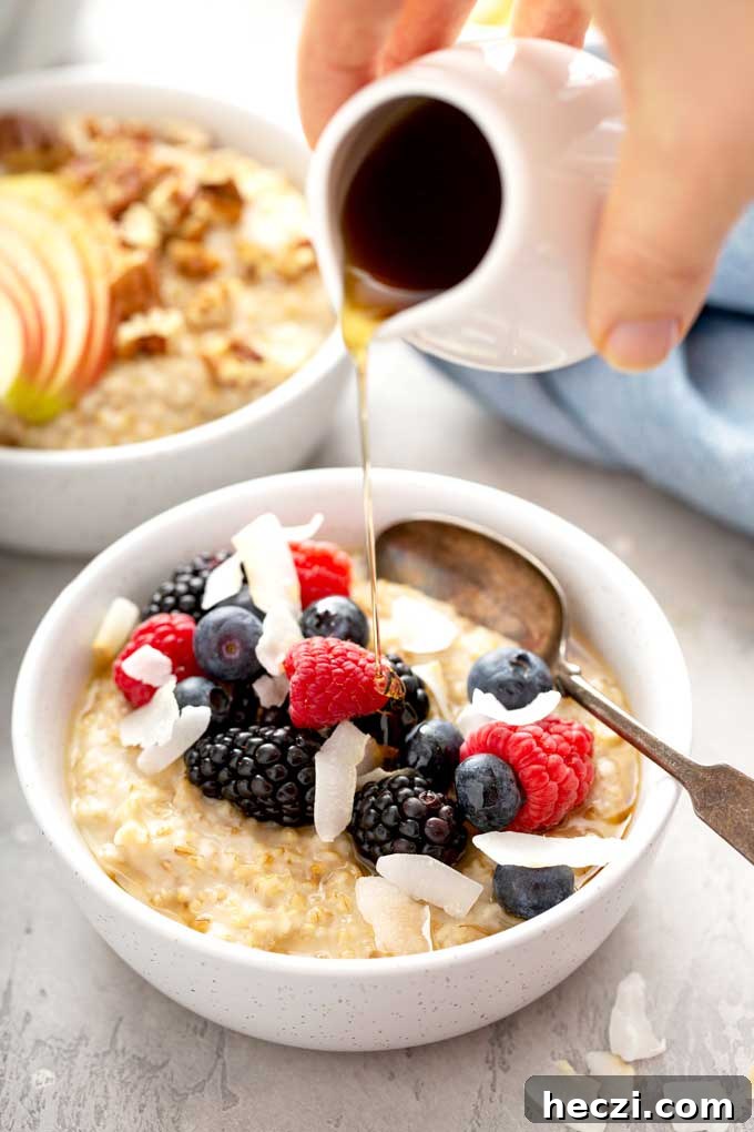 Creamy Instant Pot Steel-Cut Oats Recipe for Busy Mornings 2 A bowl of steel cut oatmeal topped with berries drizzled with maple syrup