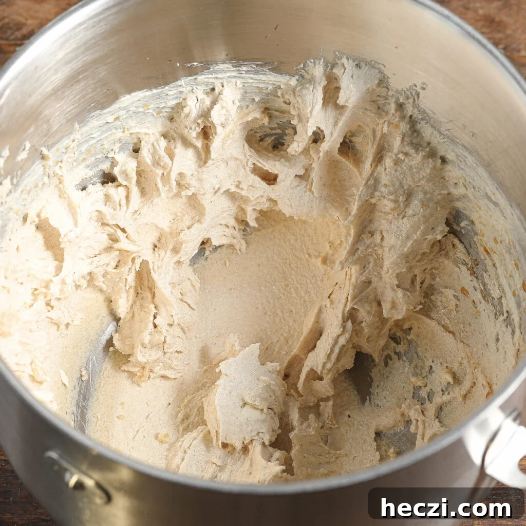 Ultimate Triple Chocolate Cookie Recipe Everyone Will Love 3 A metal mixing bowl containing creamed butter and sugar, with a light, fluffy texture smeared along the sides—perfect for starting a batch of Triple Chocolate Cookies.