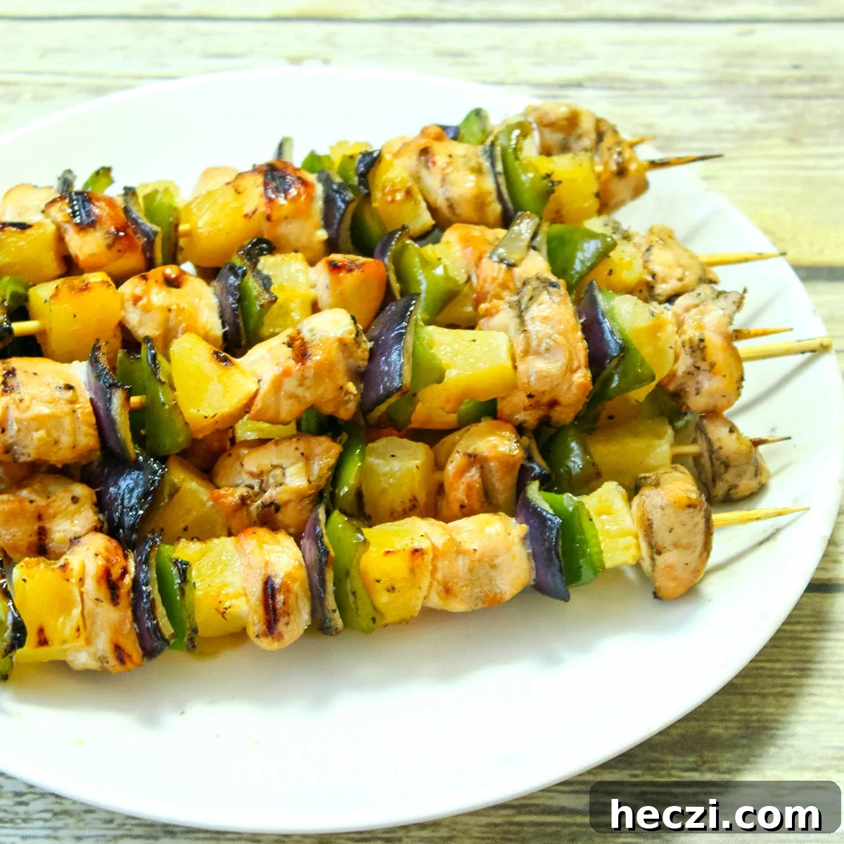 Hawaiian Chicken Kabobs with Pineapple Glaze — Grilled Recipe 2 Grilled Hawaiian Chicken Kabobs on white serving platter.