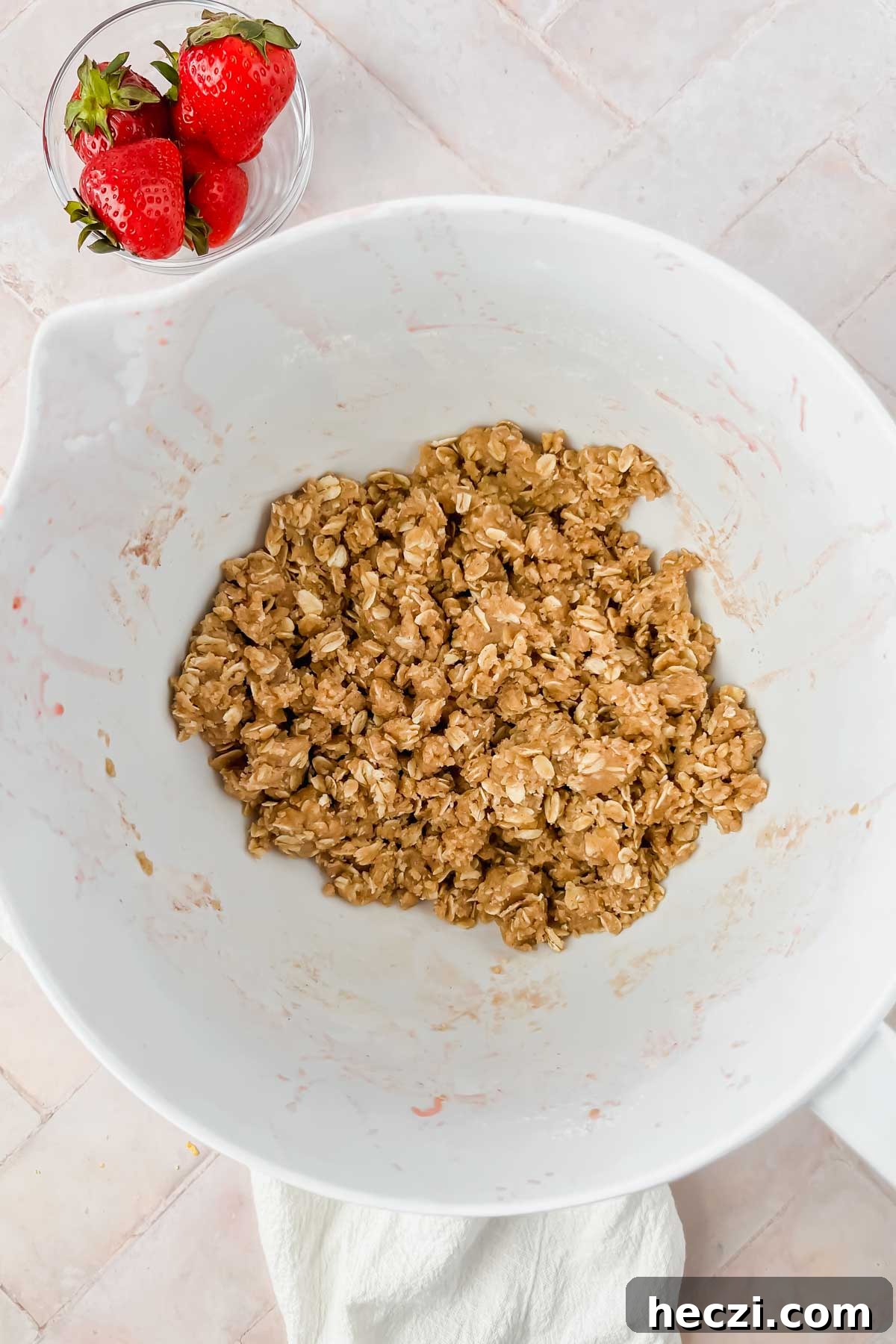 white mixing bowl filled with brown sugar oat crumble mixed together.