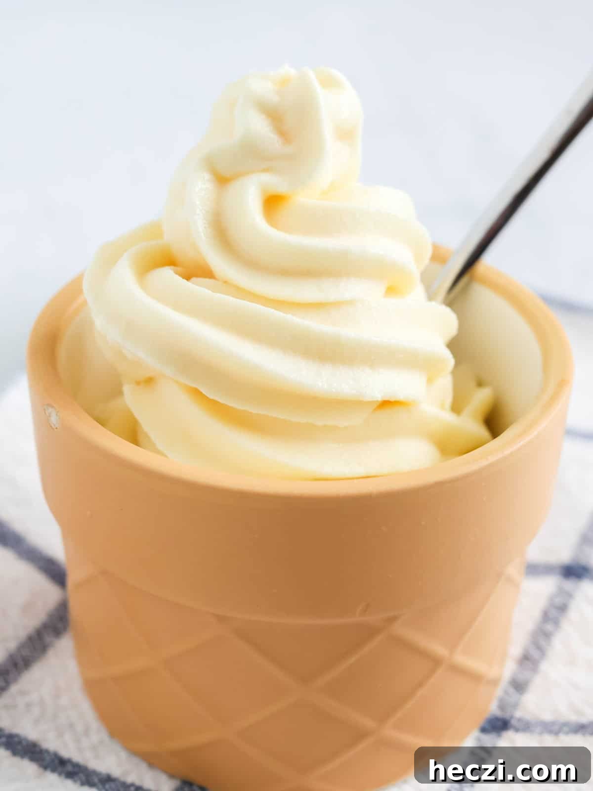 Ninja Creami Swirl vanilla soft serve ice cream in a dessert cup with a spoon.
