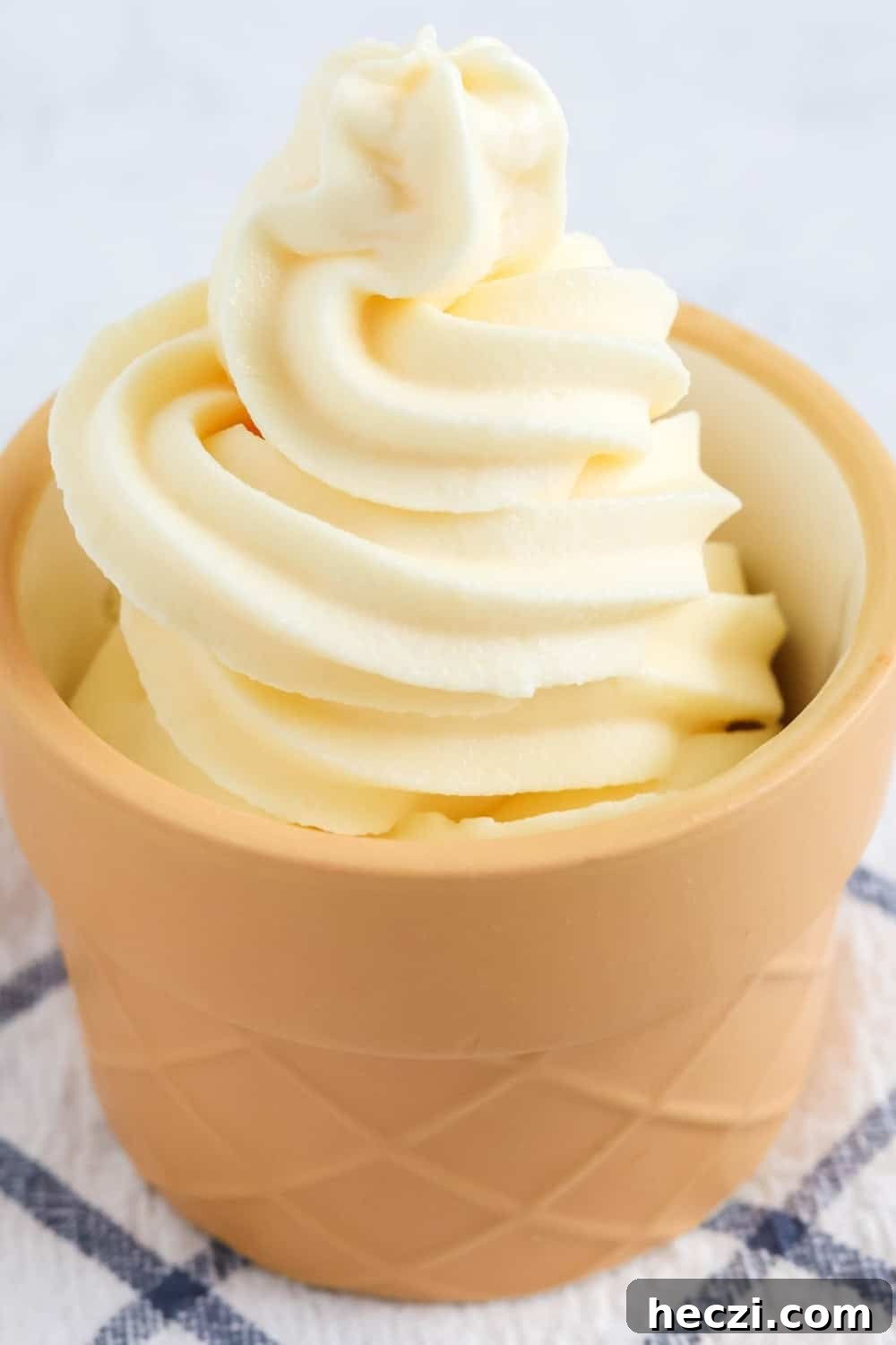 Vanilla soft serve that was made in the Ninja Creami soft serve machine, served in a cone-shaped dessert dish.