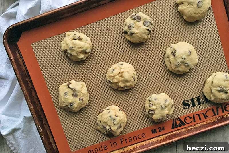 Horizontal image of baked rounds of dessert on a silicone mat.