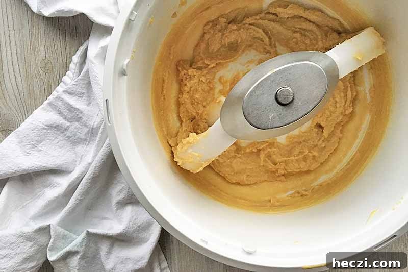 Horizontal image of a batter in a white mixing bowl on a white towel.