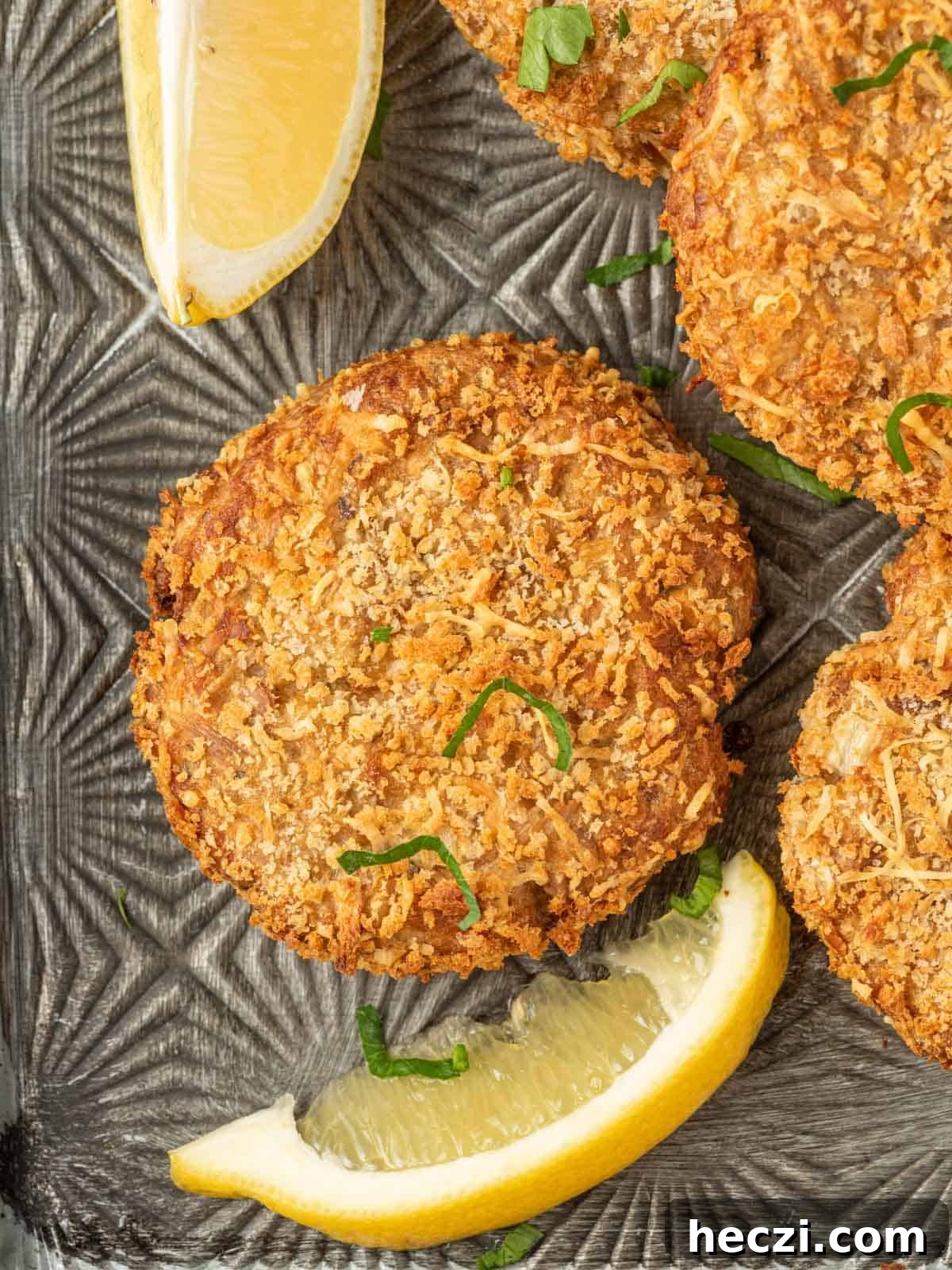 Crispy Parmesan-Crusted Tuna Patties with Lemon Aioli 6 Close up of canned tuna fish cakes with lemon wedges.
