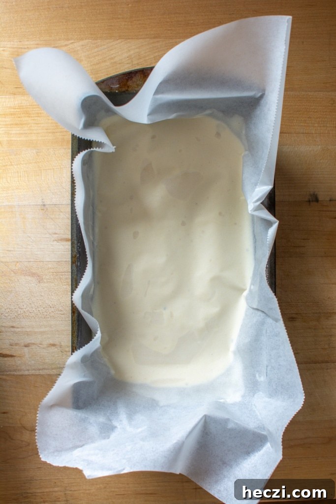 Mexican Cinnamon Ice Cream Recipe — Creamy Horchata-Style Ice Cream 12 The ice cream in a loaf pan with a piece of parchment paper on top