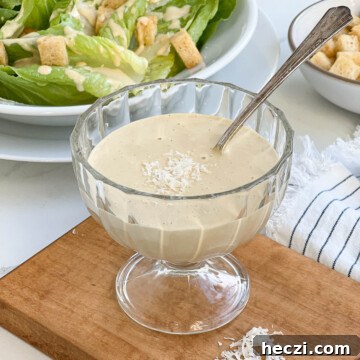A bowl of homemade caesar dressing with spoon.