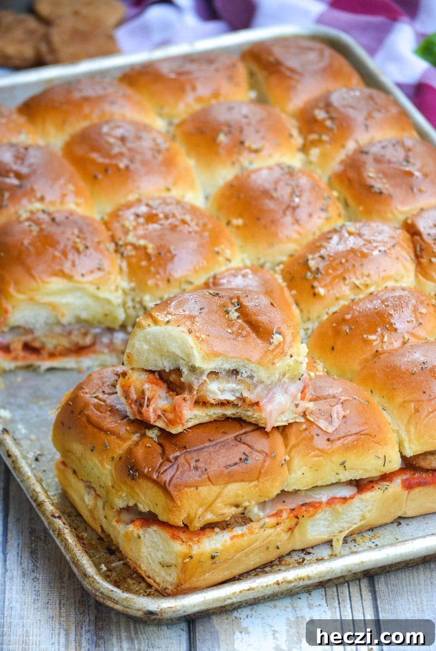Chicken Parmesan Nugget Sliders Recipe for Crispy, Cheesy Bites 5 baked chicken parmesan nugget sliders on a silver baking sheet