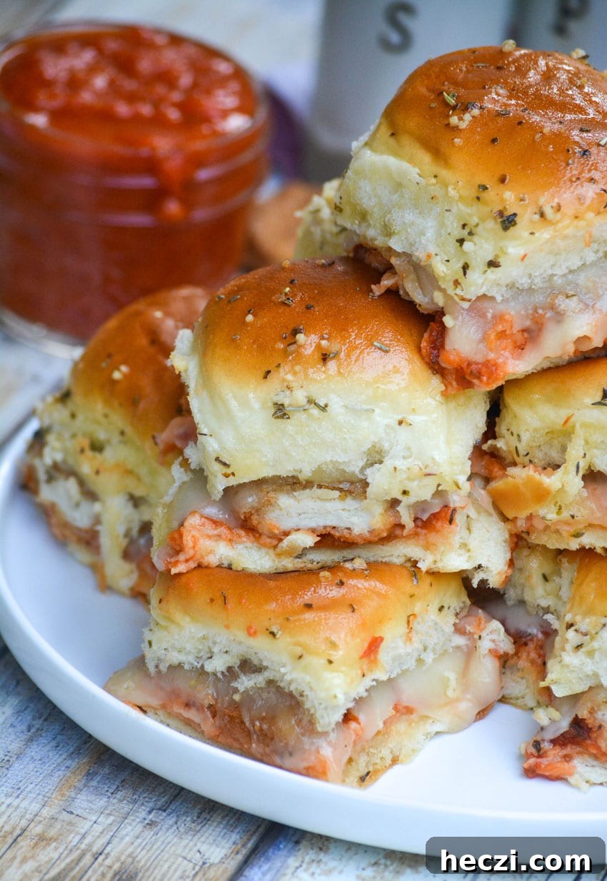 Chicken Parmesan Nugget Sliders Recipe for Crispy, Cheesy Bites 6 a stack of chicken nugget parmesan sliders on a white plate