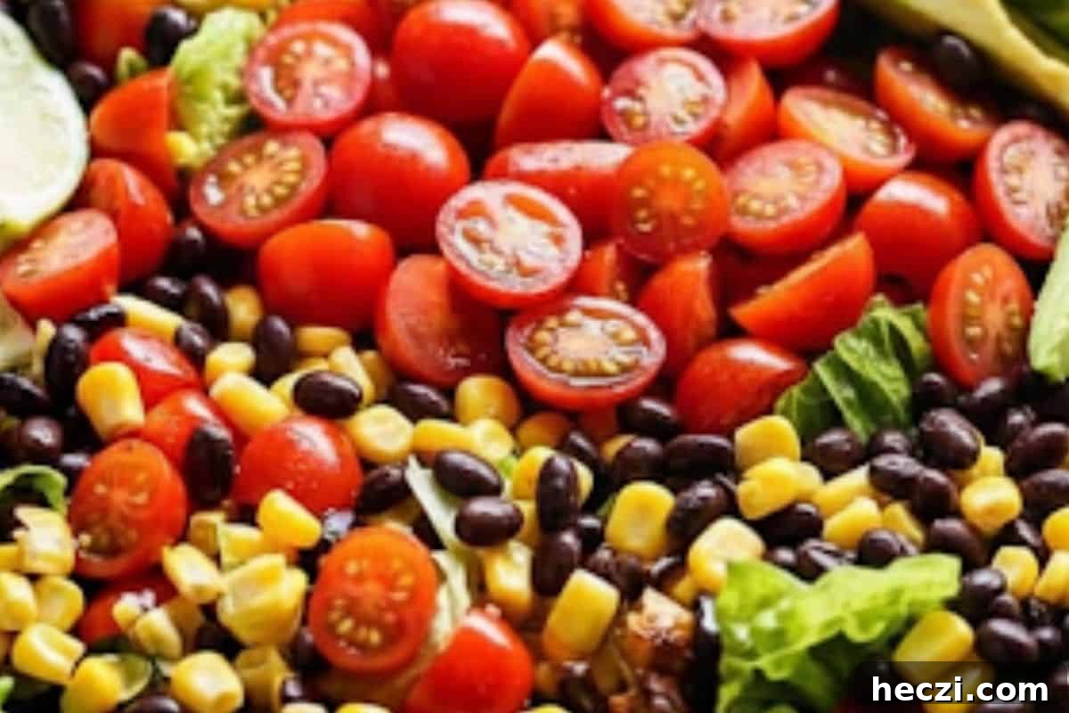 Southwestern Chicken Salad Recipe: Zesty Ingredients & Creamy Avocado 8 Arrange romaine lettuce, halved tomatoes, avocado slices, black beans, and corn in a large serving bowl.