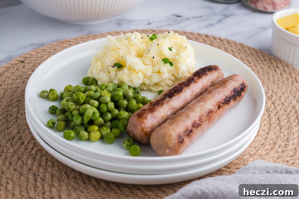 Plate with gluten-free mashed potatoes, peas, and cooked sausages.