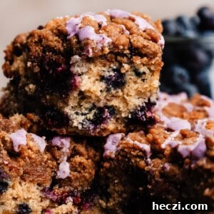 Blueberry Coffee Cake Recipe with Streusel Crumbs 16 A piece of blueberry coffee cake stacked on other slices.