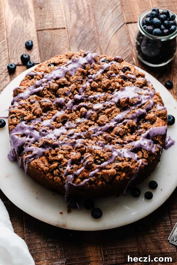 Blueberry Coffee Cake Recipe with Streusel Crumbs 8 The baked and glazed cake on a cake plate.