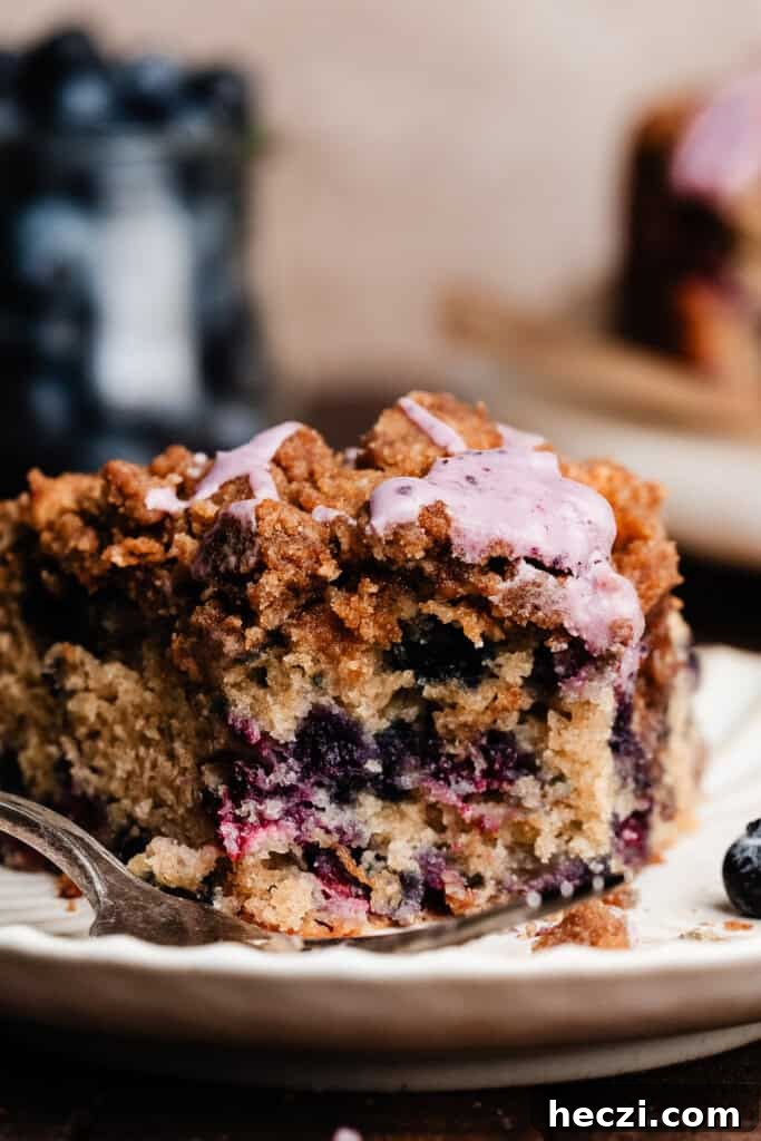 Blueberry Coffee Cake Recipe with Streusel Crumbs 10 A close-up on a slice of the cake on a plate, with bites missing.