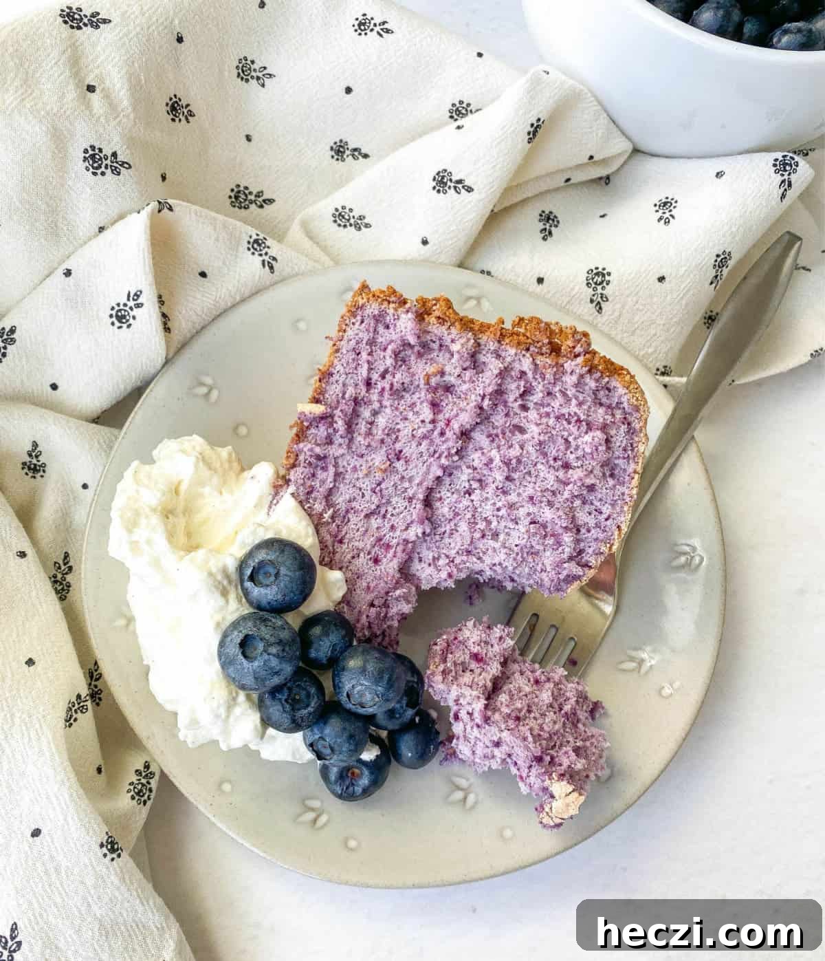 a slice of blueberry angel food cake on a plate. 