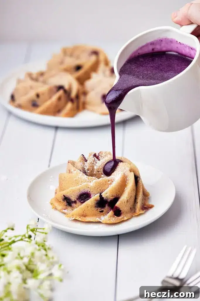pouring blueberry glaze on a blueberry bundt cake. 