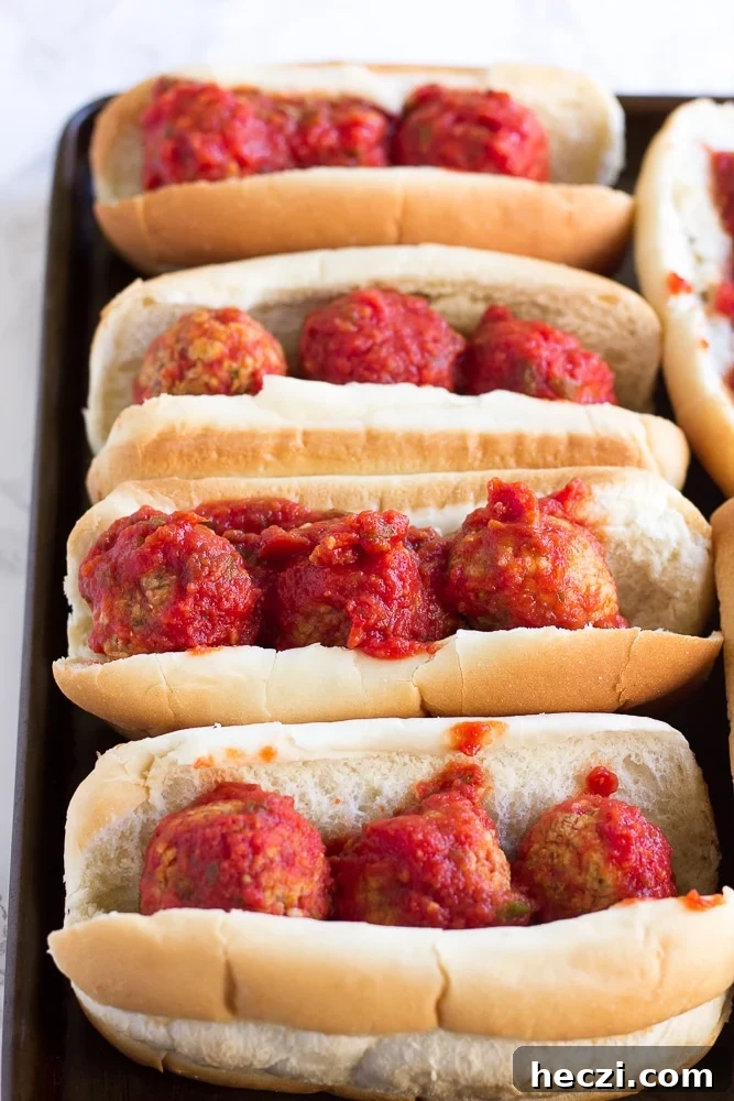 Oven-Baked Vegan Meatball Subs Recipe for Perfect Sandwiches 3 vegan meatball subs on a pan without cheese before being baked.