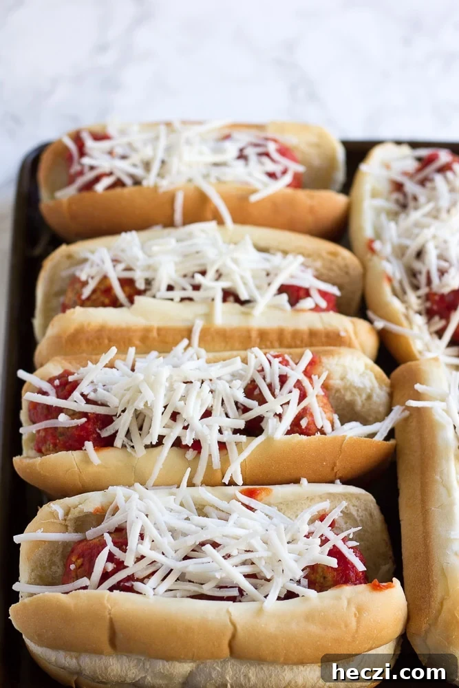 Oven-Baked Vegan Meatball Subs Recipe for Perfect Sandwiches 4 vegan meatballs subs with shredded cheese before baking.