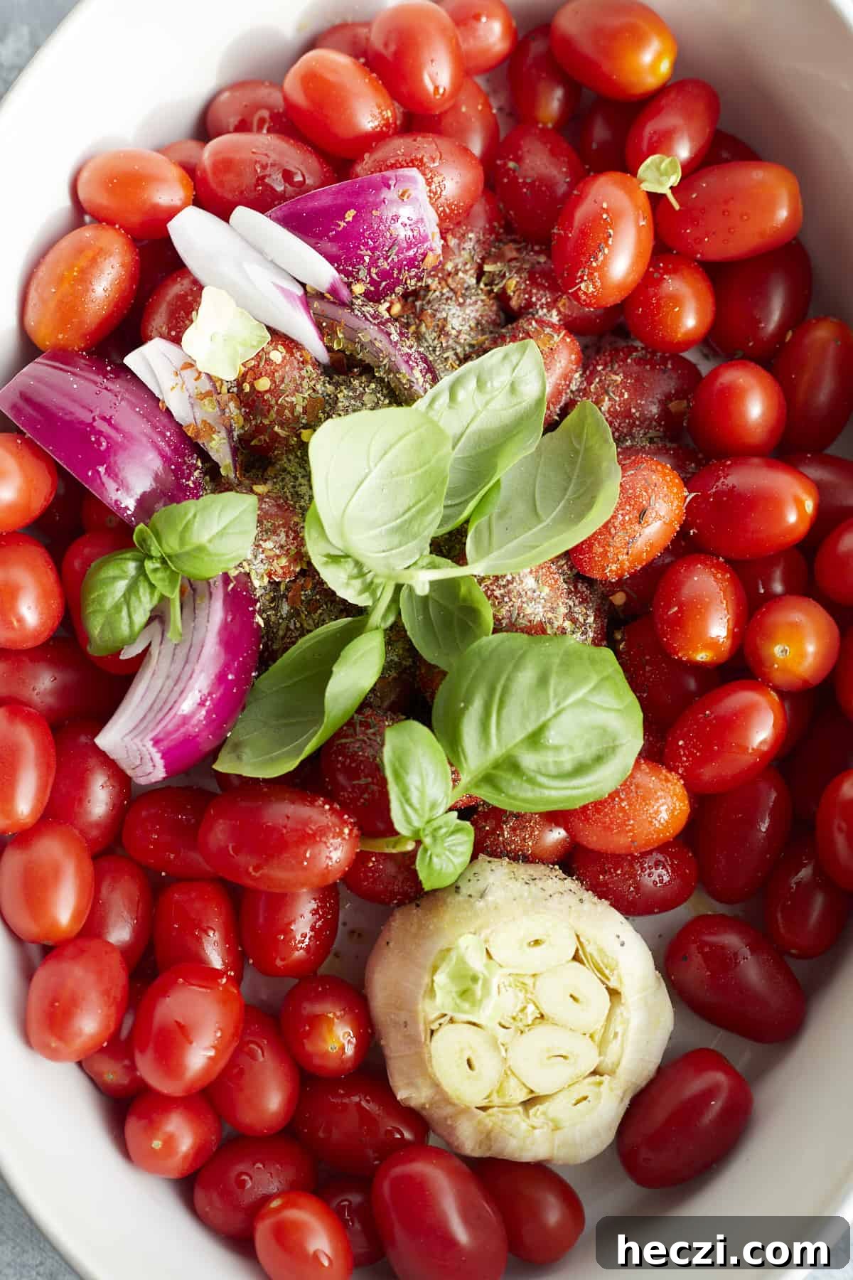 Spicy Baked Spaghetti Arrabbiata with Crispy Cheese Topping 3 a baking dish with cherry tomatoes, a whole head of garlic, red onion, shallot, basil, and seasonings