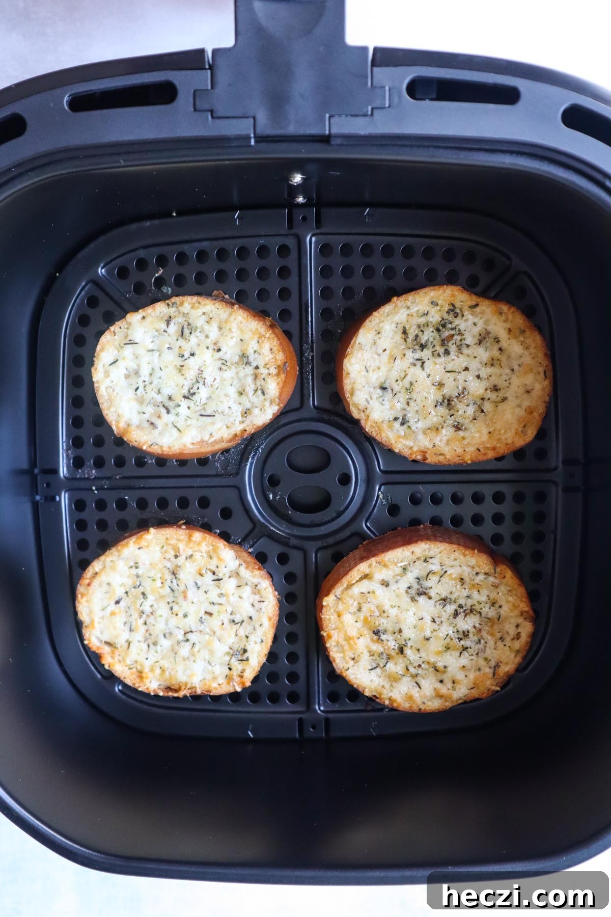 air fryer with four slices of cheese toast right after it's been cooked and the cheese is melted