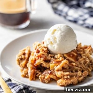 Warm Caramel Apple Crisp with Crunchy Oat Topping 11 Caramel apple crisp topped with a scoop of vanilla ice cream on a white plate