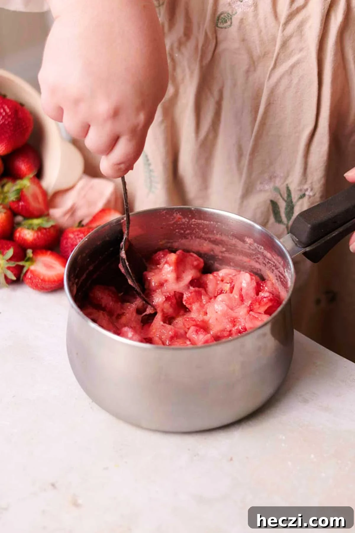 Strawberry Cinnamon Rolls with Cream Cheese Glaze 5 stirring uncooked strawberry filling in a saucepan