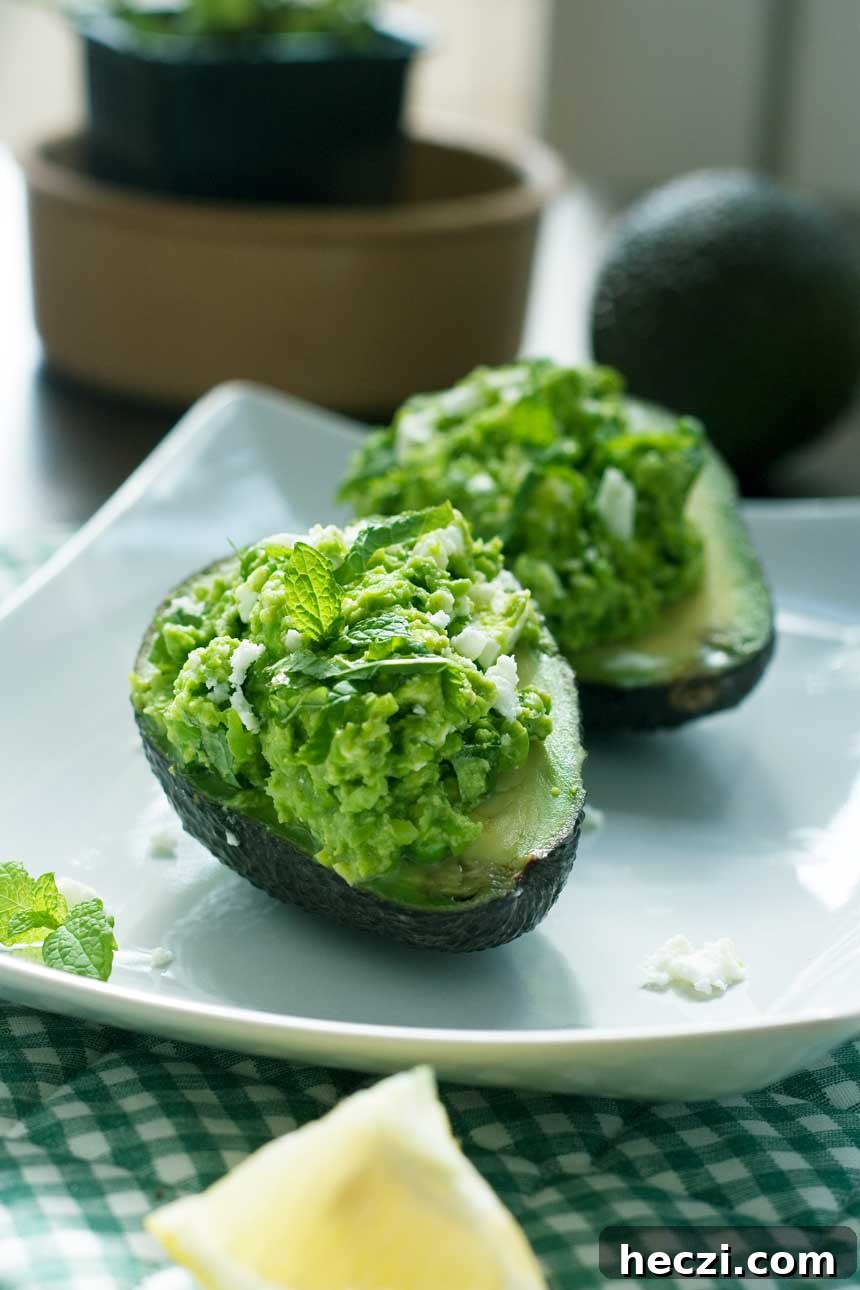 Pea, Mint & Feta Avocado Boats: Fresh Stuffed Avocado Recipe 5 Pea, mint and feta avocado boats on a white square plate.
