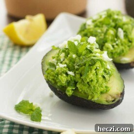 Pea, Mint & Feta Avocado Boats: Fresh Stuffed Avocado Recipe 7 A close up of avocado boats on a square white plate and a green and white checked cloth.