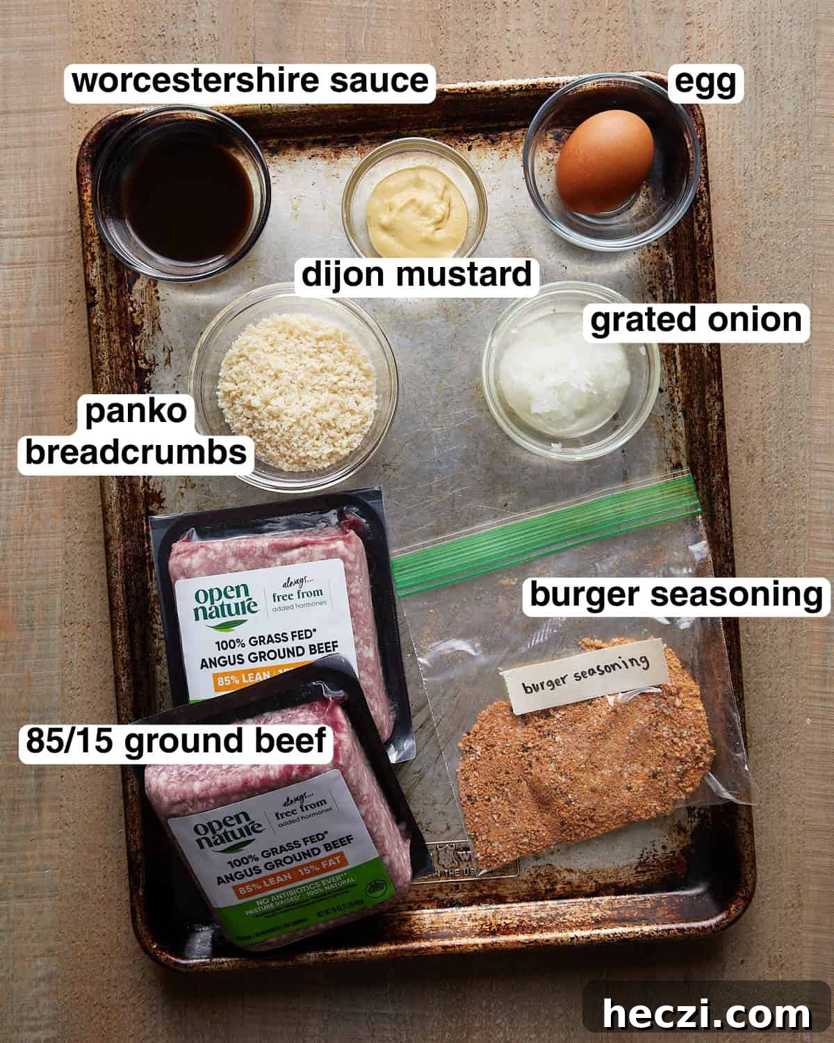 Juicy Grilled Hamburger Recipe for Perfect Summer BBQ 3 Labeled ingredients for grilled burger patties, including ground beef, burger seasoning, panko breadcrumbs, Dijon mustard, grated onion, and sauce.