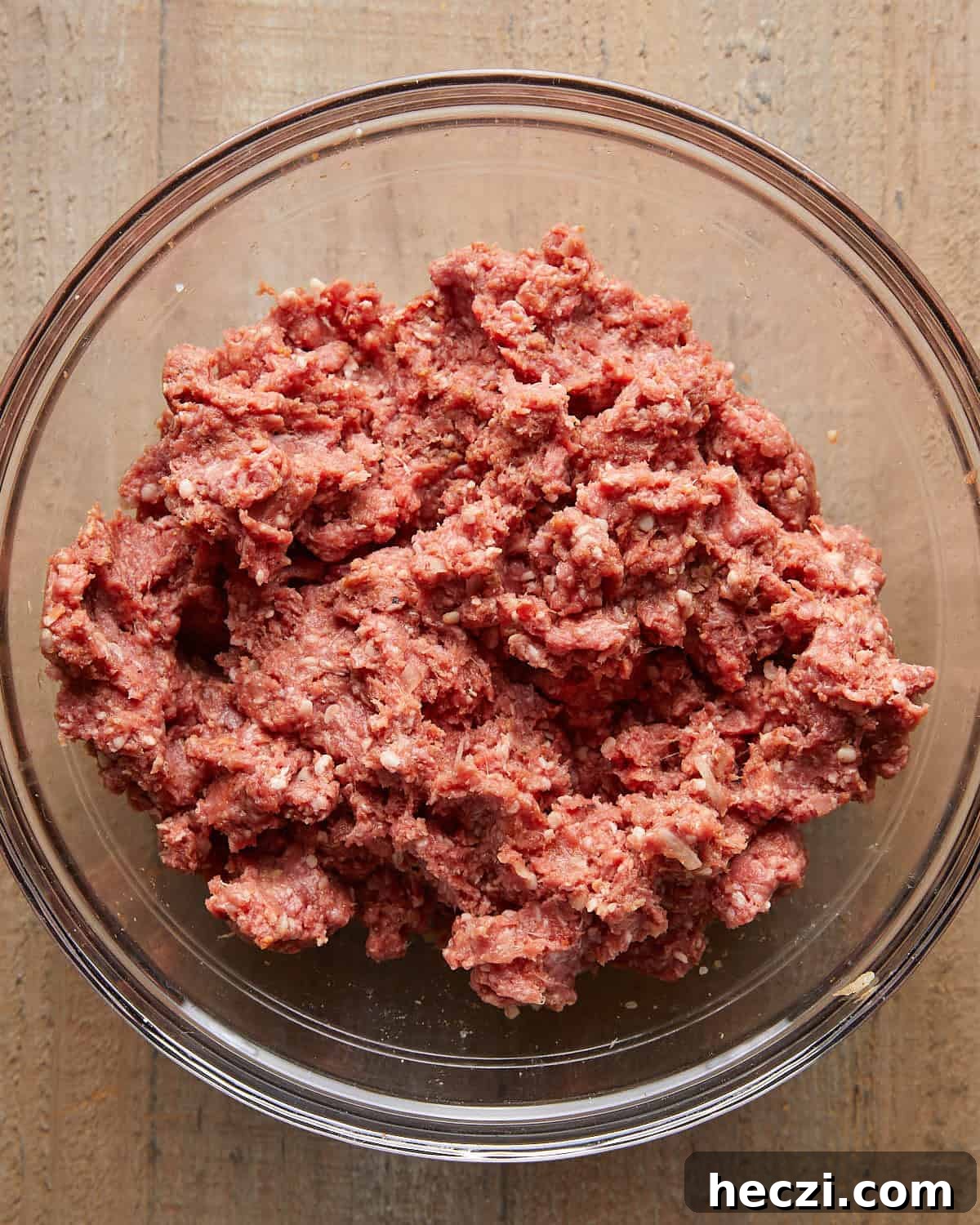 Juicy Grilled Hamburger Recipe for Perfect Summer BBQ 4 Ground beef mixture in a glass bowl before shaping into burger patties.