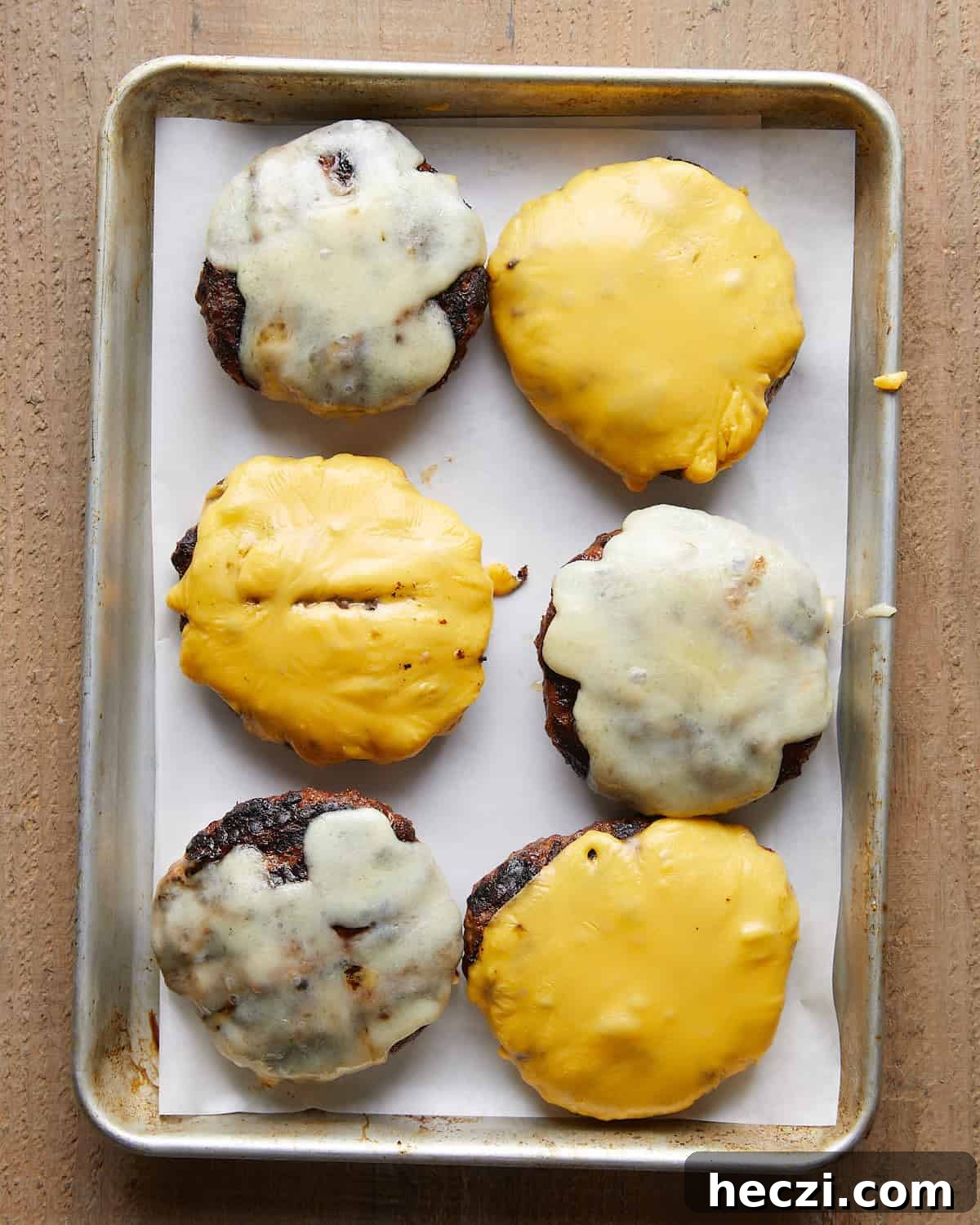 Juicy Grilled Hamburger Recipe for Perfect Summer BBQ 6 Grilled burger patties topped with melted cheese.