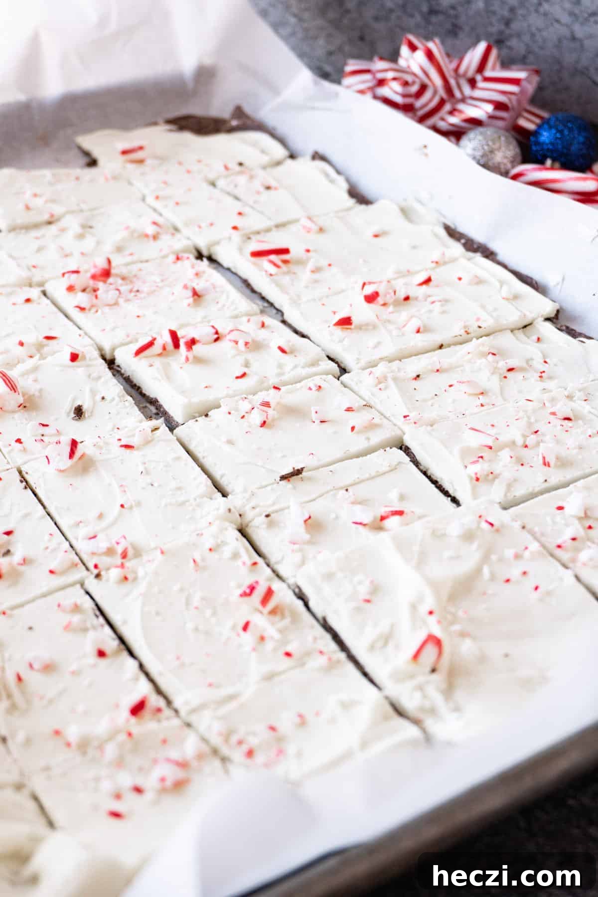 Homemade Peppermint Bark Recipe: Quick Holiday Chocolate Candy 11 peppermint bark om parchment lined baking sheet cut into squares.