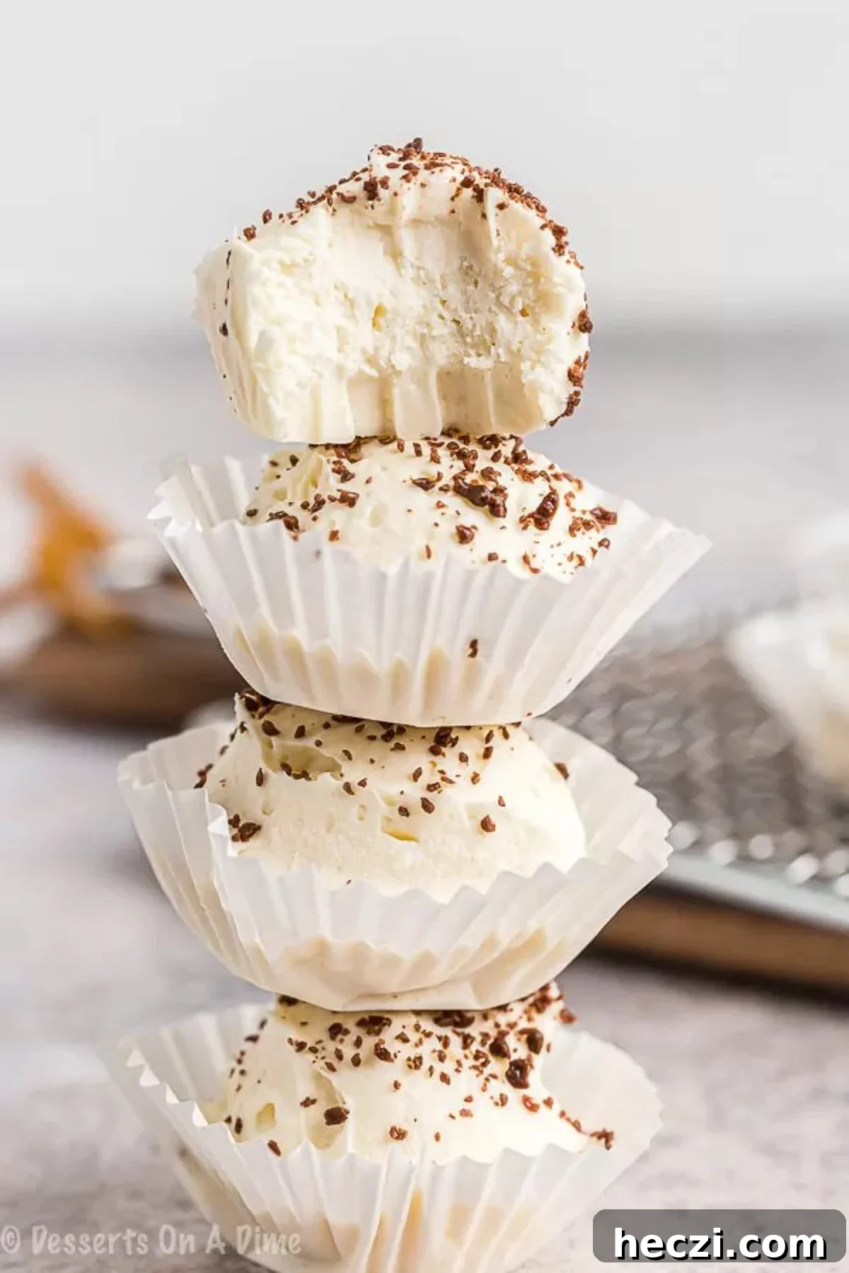 Keto cheesecake fat bomb recipe is a game changer. You can enjoy decadent cheesecake that is keto friendly without any guilt. Keto Cheesecake Fat bombs in a cupcake holder stacked.