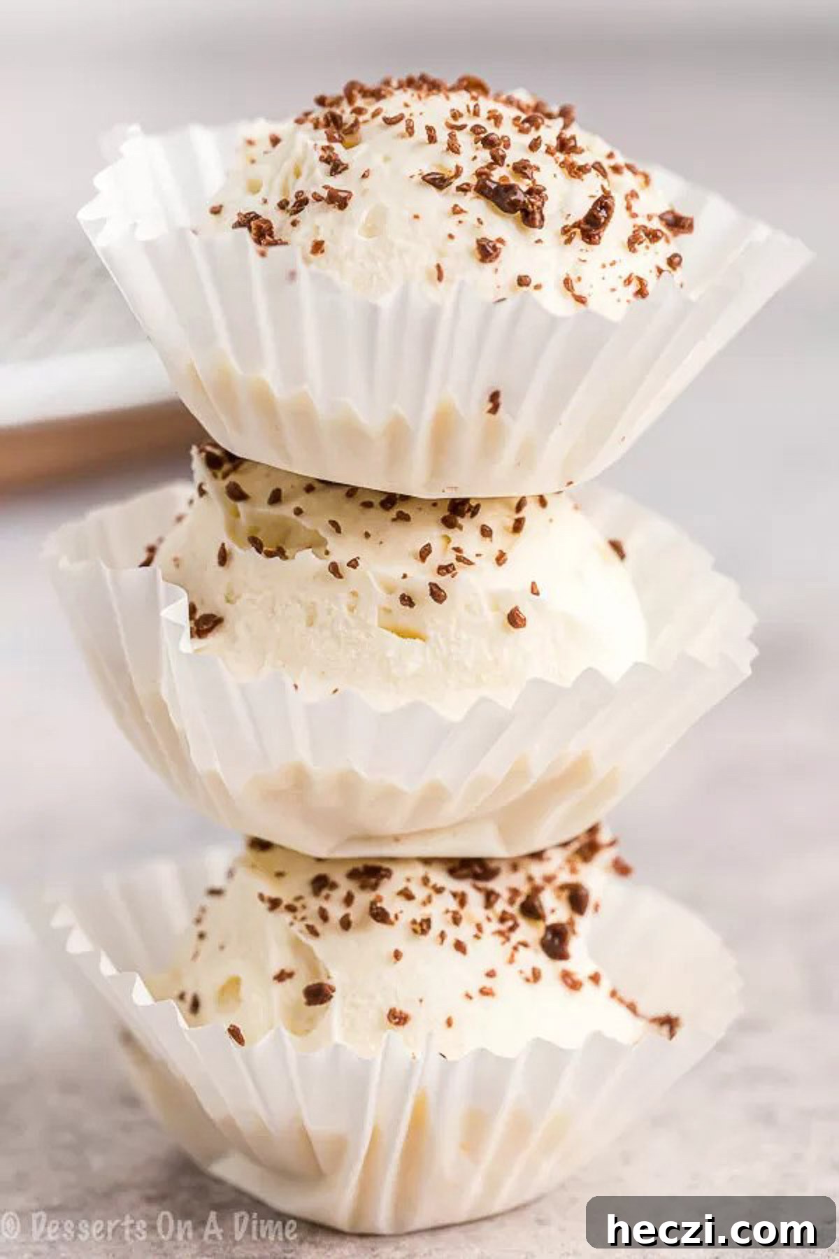 Keto cheesecake fat bomb recipe is a game changer. You can enjoy decadent cheesecake that is keto friendly without any guilt. Keto Cheesecake Fat bombs in a cupcake holder stacked.