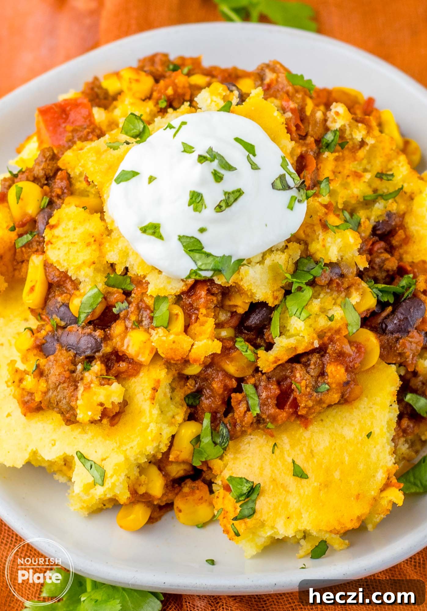 Plated portion of cornbread casserole topped with a dollop of sour cream