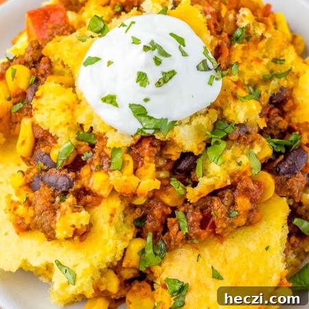 Plated portion of cornbread casserole topped with a dollop of sour cream