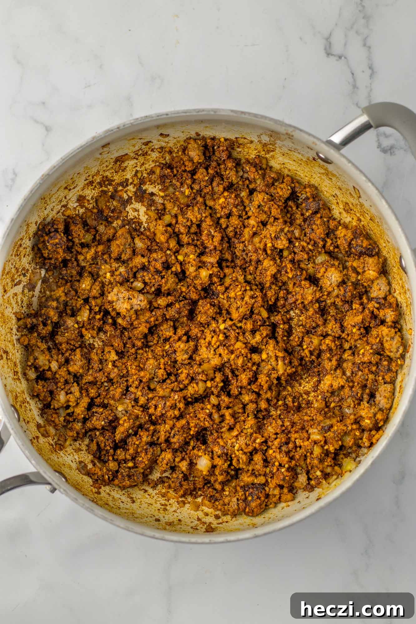 Sauteed ground beef in a skillet with seasonings