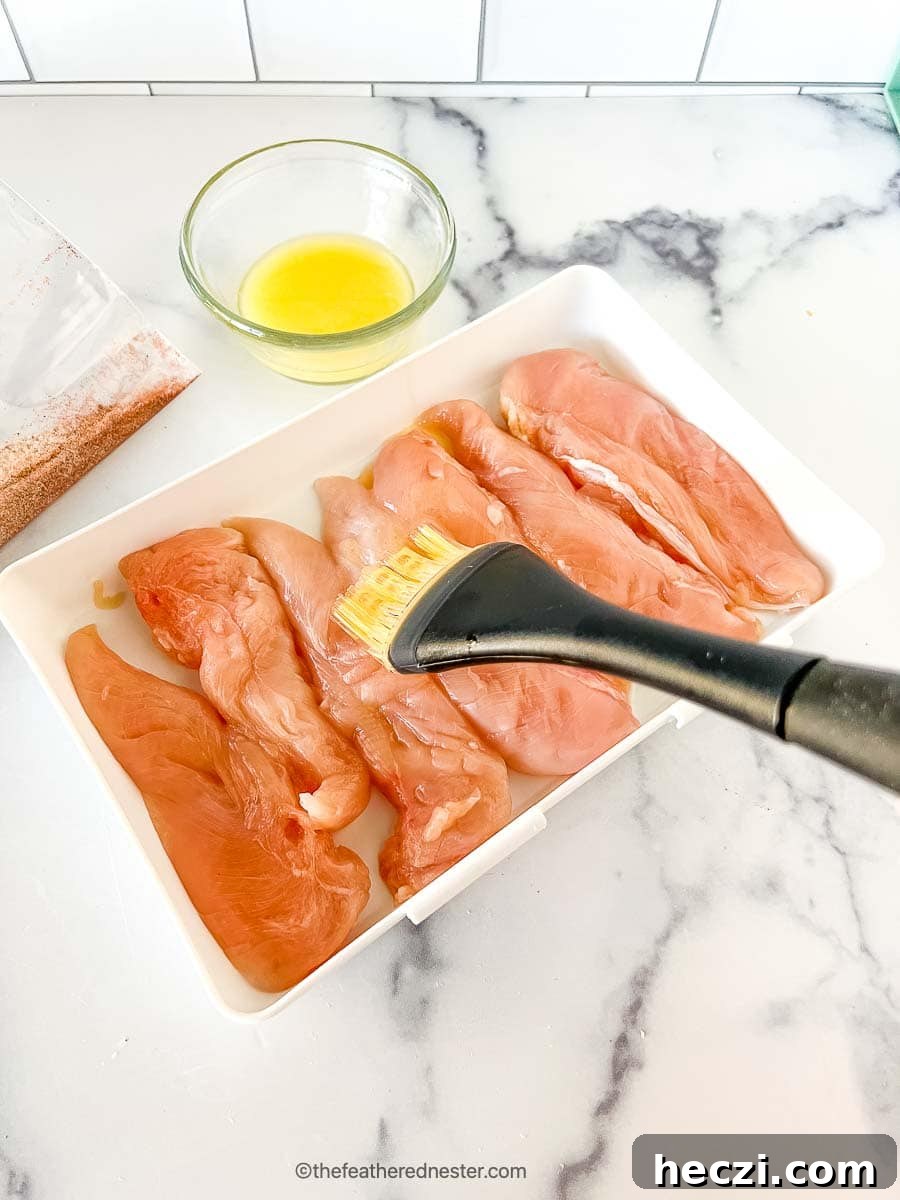 Crispy Shake-and-Bake Chicken Recipe for Oven or Air Fryer 5 Basting melted butter to the chicken tenderloins on a casserole.