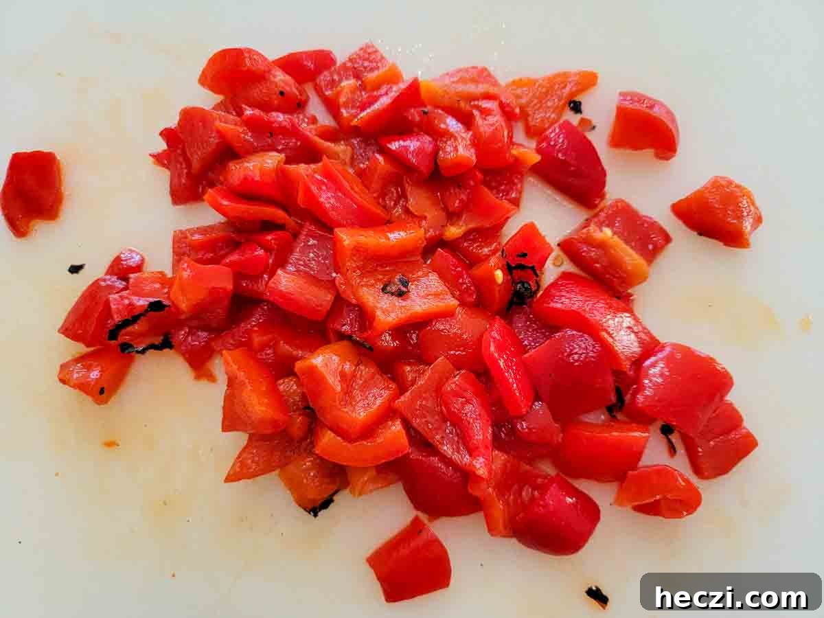 roasted red peppers diced on a cutting board.
