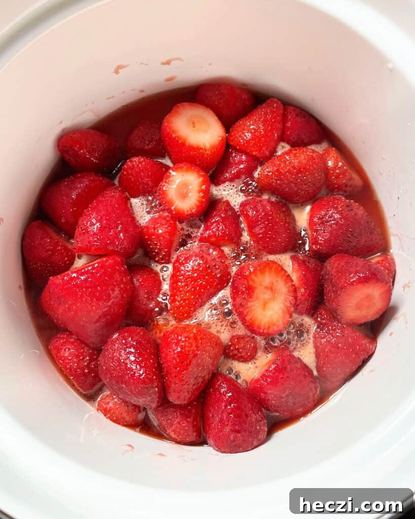 4-Ingredient Strawberry Compote Recipe for Fresh Homemade Jam 5 Simmering strawberries and juices in a white saucepan.